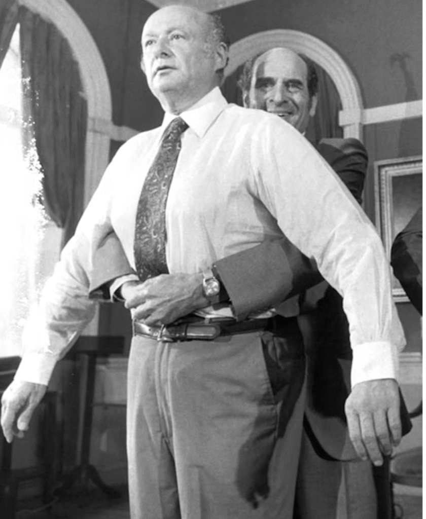 La Manœuvre de Heimlich : démonstration où un homme positionne ses bras autour de la taille d’un autre pour illustrer les compressions abdominales."